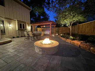 Luxury backyard patio with outdoor fireplace by Leawood concrete company
