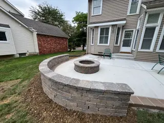 Overland Park concrete patio with curved stone seating wall and fire pit