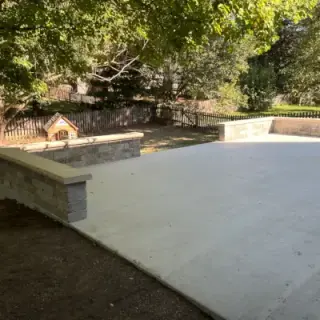 Concrete patio design with decorative stone accent wall