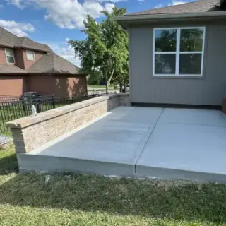 Retaining wall integrated with concrete patio