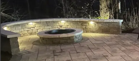 Illuminated outdoor fire pit at dusk