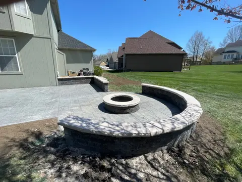 Stamped concrete patio with fire pit and seating wall
