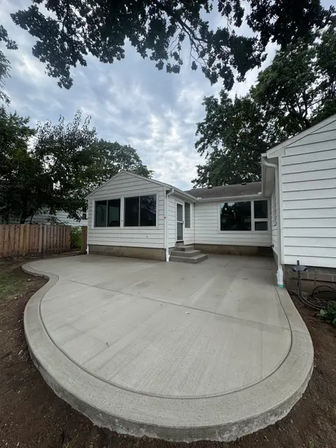 Curved backyard concrete patio at a Prairie Village, KS home