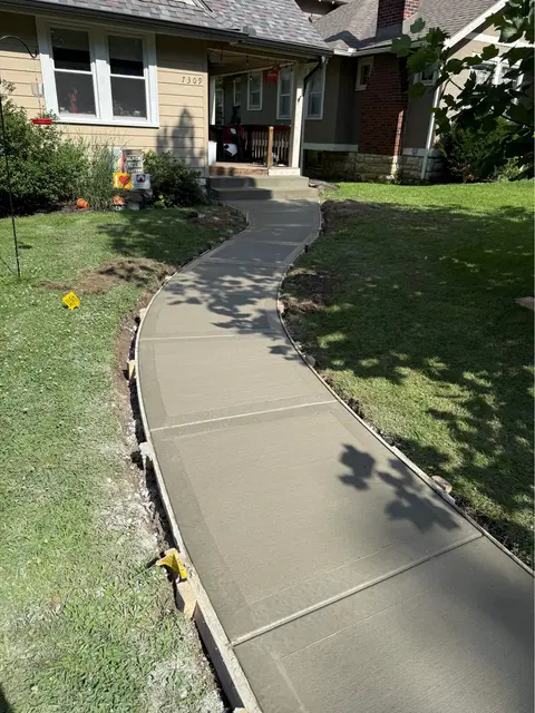 Rounded picture-frame concrete sidewalk leading to front door